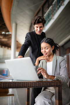 Latino man and African American businessperson brainstorming startup small business strategy together. Young multiracial businesswoman and colleague serious working on planning. Diversity people team.