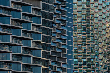 Close-up of contemporary glass building facades with reflections, showcasing modern urban architecture and geometric design in Dubai city, UAE. Abstract architecture background