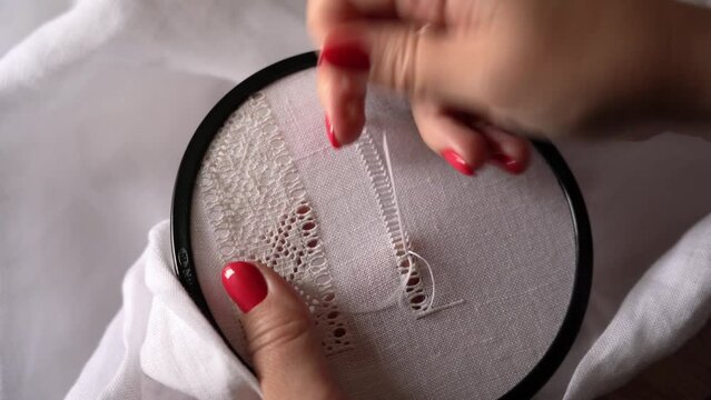 Embroidery Stitches for a Lace Design on White Fabric. Process of creating traditional Ukrainian embroidery