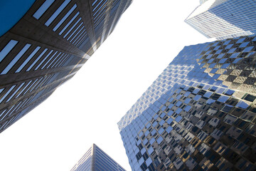 Upward view of modern skyscrapers against a clear sky, showcasing architectural design and...