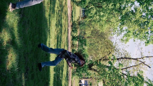 vertical video outdoors in a park with trees a young brunette guy with a brunette girl playing bambinton best friends relaxing together the girl serves