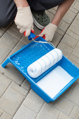 Construction work, plastering and wall priming. Builder's hand with paint roller.