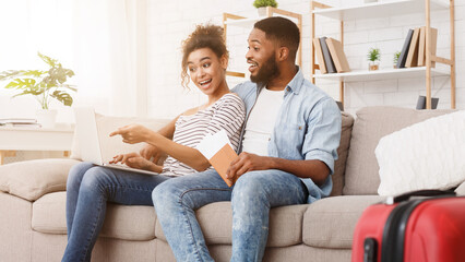 Happy couple searching places to visit using laptop, planning tour abroad