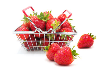 Shopping supermarket basket with fresh organic ripe strawberries whole and heap isolated on a white...