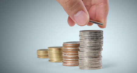 Hand laying coins on stacks coins in  row ,Business idea