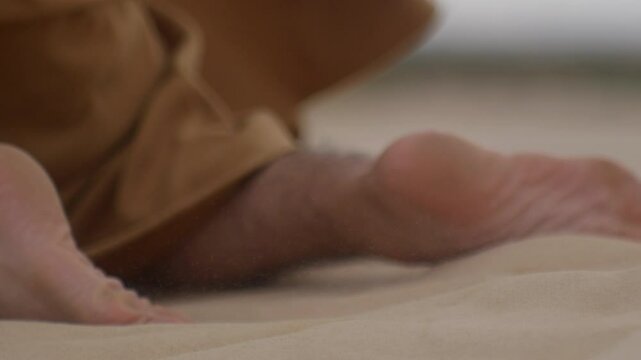 male monk in robe Crowl on desert storm sand looking for a shelter and water for saving his own life