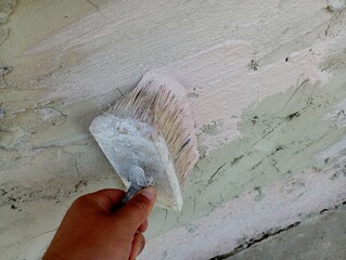Priming the concrete surface with a brush. Manual application of the primer on the concrete surface...