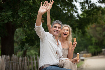 aged couple eating ice raising hands up