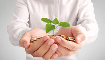 Businessman holding plant sprouting from a handful of coins