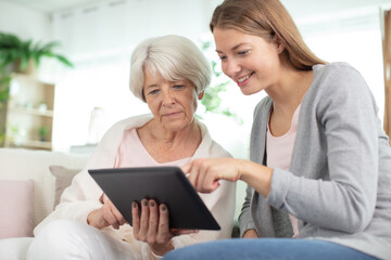 beautiful old woman and girl are using a digital tablet