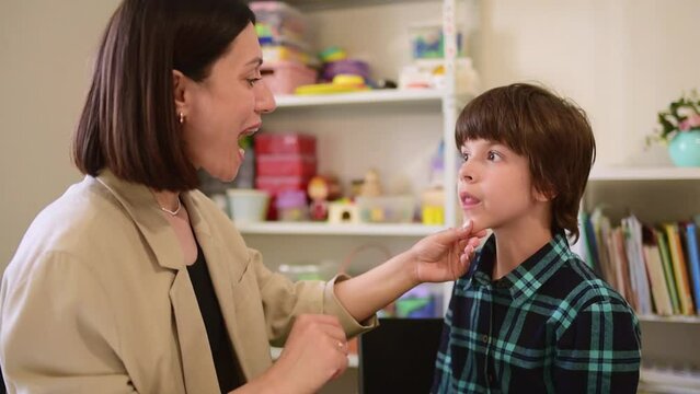 Cute preschool child is engaged in speech therapist office and correcting his speech