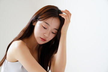 Fototapeta premium 自然光で撮影をした若い女性の美容イメージ