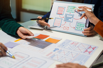 UX developer and ui designer brainstorming about mobile app interface wireframe design with...