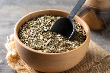 Traditional yerba mate in wooden bowl on wooden table