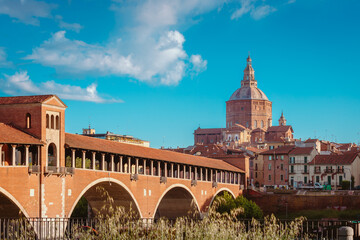 Main attractions of the historic city of Pavia, Ponte Vecchio and Duomo with blue sky and white...
