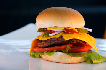 Great tasty burger close up. It is seen cutlets, onions, lettuce, crispy loaf with golden 