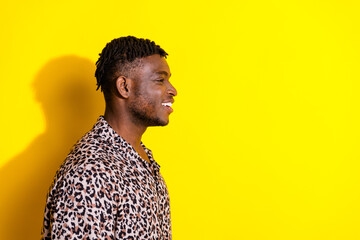 Photo of cheerful glad nice man wear trendy clothes look empty space offer isolated on vibrant yellow color background