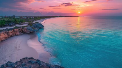 Obraz premium Tranquil beach with turquoise waters and a vibrant sunset