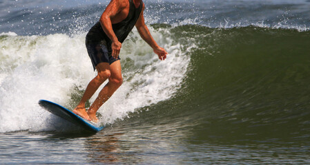 Close up of a man wearing black clothes while surfing