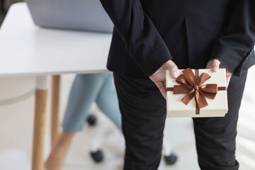 young manager prepared gift box to give to the beautiful secretary in the office to express the love and friendship they had shared between working together for long time. Friendship and love concept