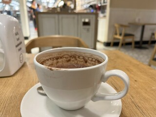 Half-drink hot chocolate drink on wooden table cafe, selected focus