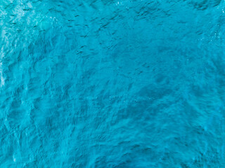 Aerial view of a blue sea surface water texture background,Sun reflections over ocean, Aerial flying drone view Waves water surface texture on sunny tropical ocean in Phuket island Thailand