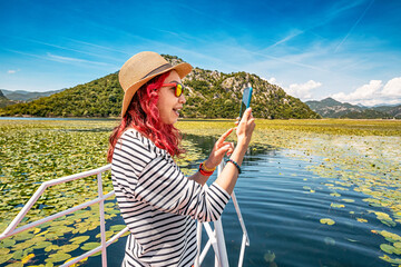 Blogger filming a scenic tour of the Balkan wilderness on Lake Skadar.