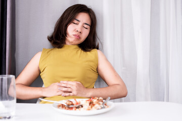 asian woman suffering from stomachache and discomfort after eating a meal, gastrointestinal concept 