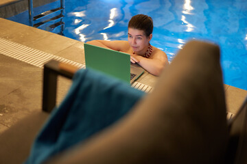 Woman Using Laptop by Swimming Pool Edge
