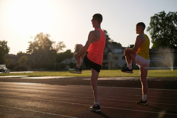 Two athletes runners warming up at the stadium before the race