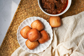 Fried Mantou served in white plate with Beef Rendang.  Fusion food.