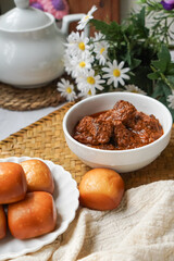 Fried Mantou served in white plate with Beef Rendang.  Fusion food.