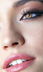 Closeup macro shot of human smiling female face. Woman with eyes and lips beauty makeup