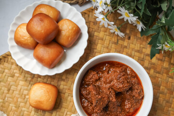Fried Mantou served in white plate with Beef Rendang.  Fusion food.