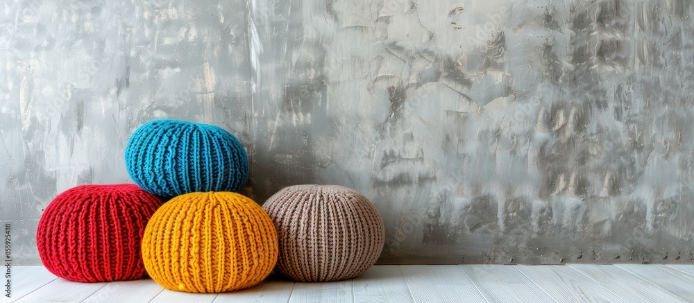 Poster three colorful knitted poufs in front of a concrete wall. copy space image. place for adding text an