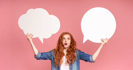 A woman is standing and holding two speech bubbles in front of her face. She appears to be engaged in a conversation or making a public statement, with the speech bubbles emphasizing her words