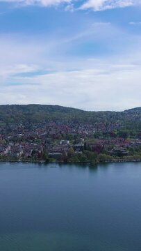 Zurich City and Zurich Lake on Sunny Day. Eastern Part of City, Hochschulen and Seefeld Districts. Switzerland. Aerial View. Drone Moves Sideways. Vertical Video