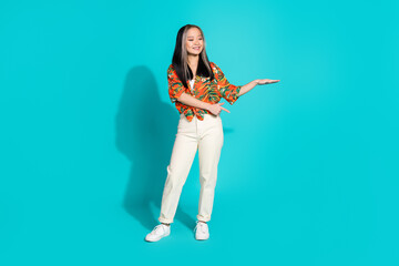 Full length photo of shiny attractive lady dressed print shirt pointing finger showing arm empty space isolated blue color background