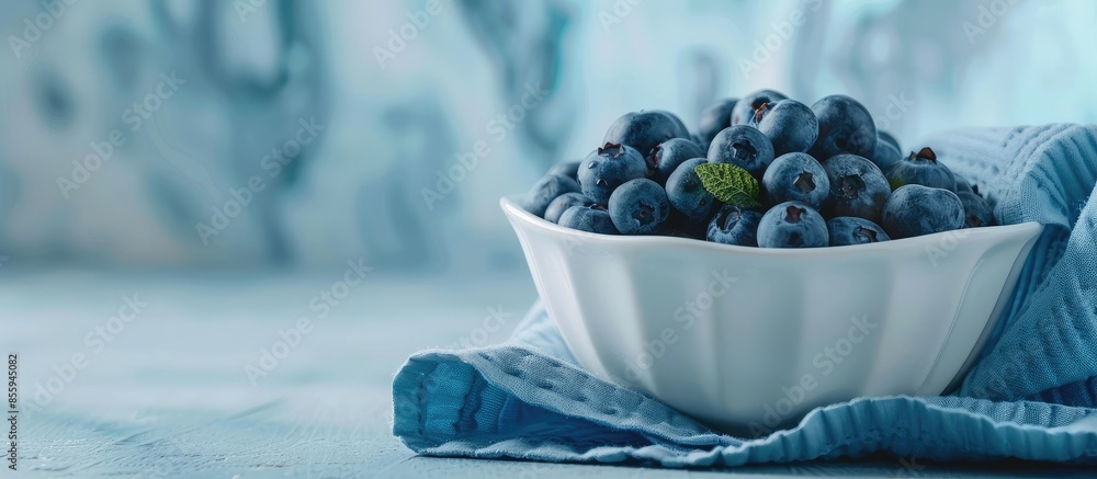 Poster closeup of blueberries in white porcelain bowl with blue napkin isolated on pastel background. shall