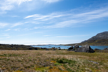 Greenland Nanortalik arctic lava stones volcanic mountain landscape on a sunny day with feather clouds