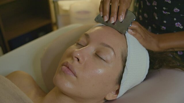 Experience the benefits of Facial Massage Therapy using a Gua Sha Tool in a relaxing spa ambiance
