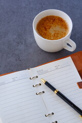 ミルクをたっぷり入れたコーヒー、カフェ・ラッテを飲みながら、日記をつけているイメージ
