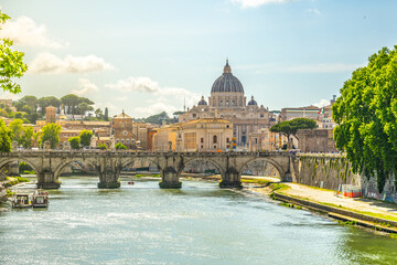 A view of the Tiber River in Rome, with a bridge in the foreground and St. Peters Basilica in the...