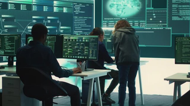 Governmental hackers team securing computer systems from cyber threats, working together in agency control room. Emphasizing encryption, online security and espionage against cyber attacks. Camera A.