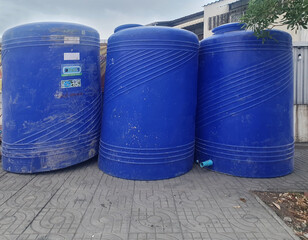 BANGKOK, THAILAND - JUNE 25, 2024: Rows of large blue plastic water tanks, holding 3000 liters, is...