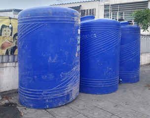 BANGKOK, THAILAND - JUNE 25, 2024: Rows of large blue plastic water tanks, holding 3000 liters, is...