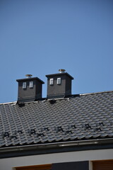 Black roof with chimney on sunny day 
