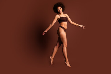 Full length photo of funny adorable lady underwear jumping accepting imperfect skin isolated brown color background