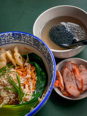 Noodle soup with wonton dumplings and vegetables. separate sauce. Top view