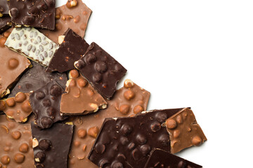 Milk and dark pieces of hazelnut chocolate on white background.